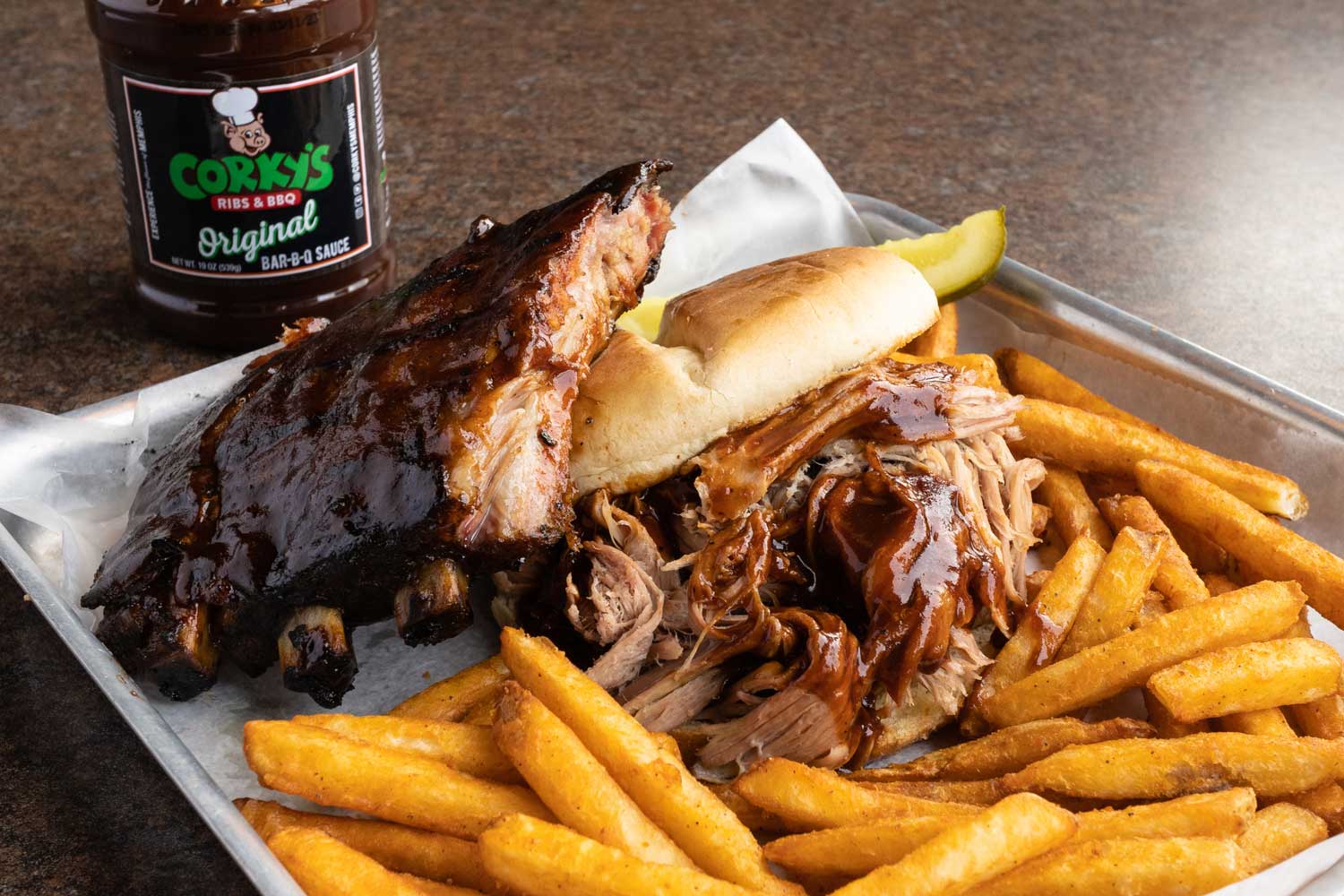 ribs, pulled meat sandwich and fries on a tray